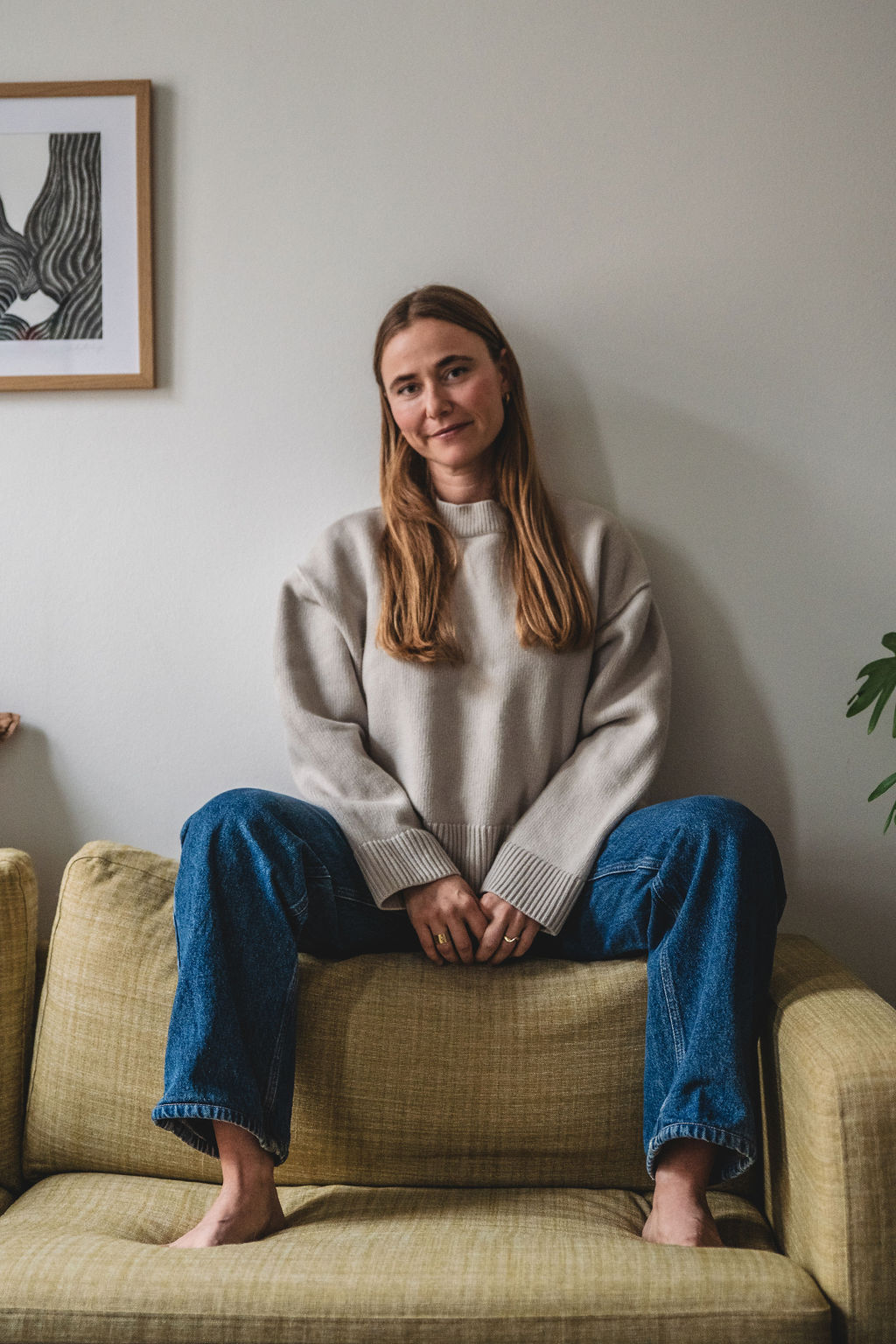 Jeanne siddende afslappet på den grønne sofa